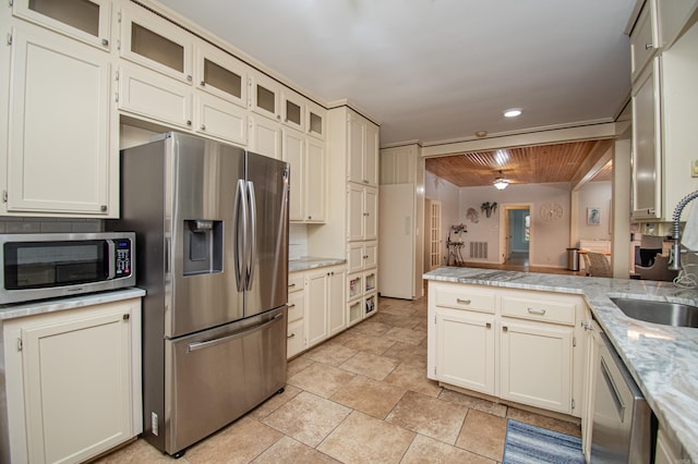 kitchen with appliances with stainless steel finishes, sink, light stone counters, light tile patterned flooring, and wooden ceiling