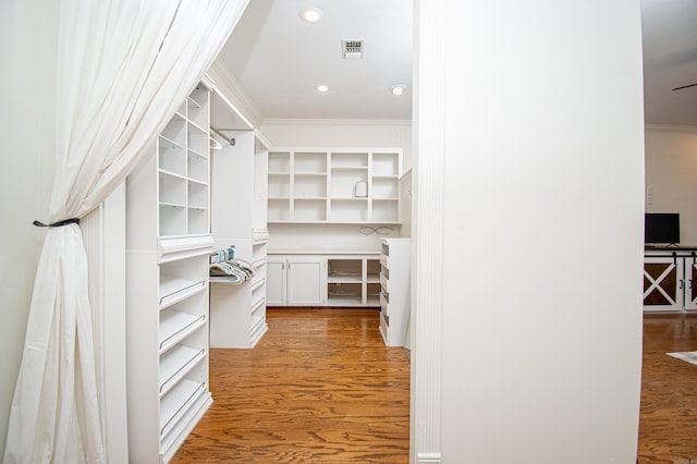 walk in closet with light hardwood / wood-style flooring