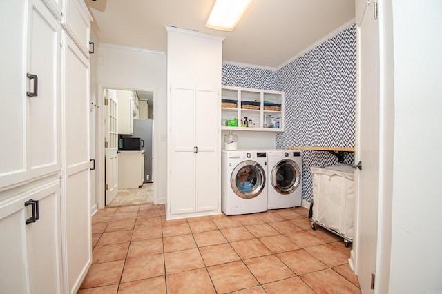 laundry room featuring laundry area, crown molding, washing machine and clothes dryer, and wallpapered walls