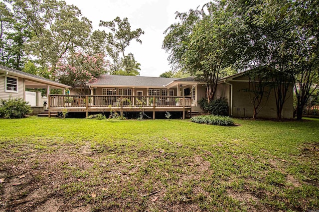 back of house with a carport, a deck, and a lawn