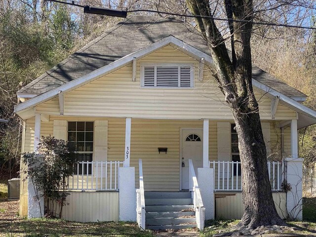 bungalow-style home with covered porch and central air condition unit