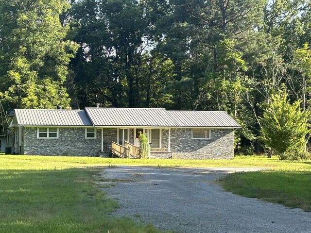 single story home featuring a front yard and central AC unit