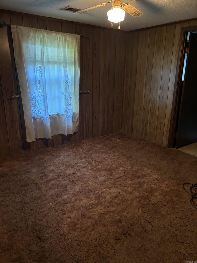 bathroom with wooden walls, ceiling fan, and vanity