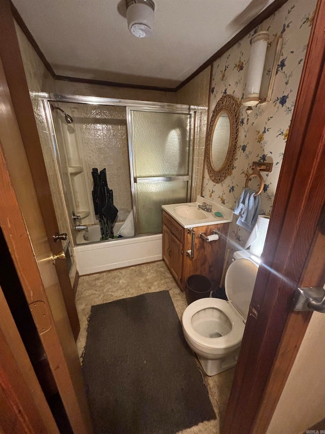 full bathroom featuring bath / shower combo with glass door, vanity, crown molding, and toilet