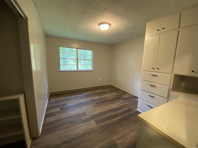 unfurnished bedroom with dark wood-style floors and a textured ceiling