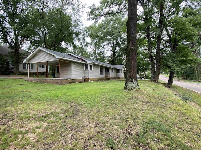 view of front of home with a front yard and a carport