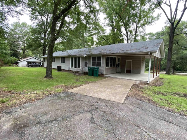 view of front of property with driveway, an attached carport, and a front lawn