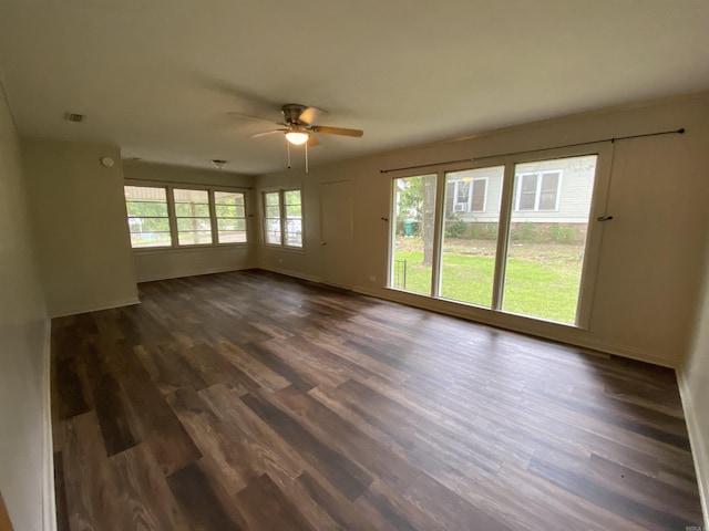 spare room with dark wood-style floors, a ceiling fan, and baseboards