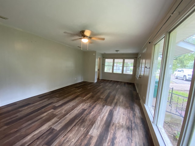 spare room with a ceiling fan, crown molding, dark wood-style floors, and visible vents