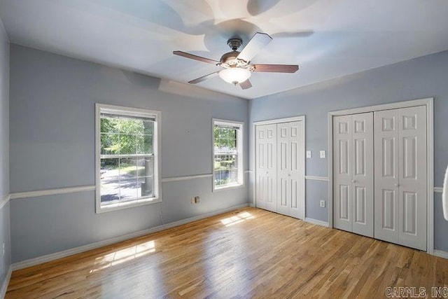 254 S Enid Ave, Russellville, AR 72801 - unfurnished bedroom with two closets, hardwood / wood-style flooring, and ceiling fan