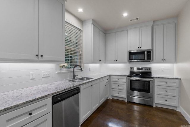 kitchen with white cabinetry, sink, light stone countertops, and appliances with stainless steel finishes