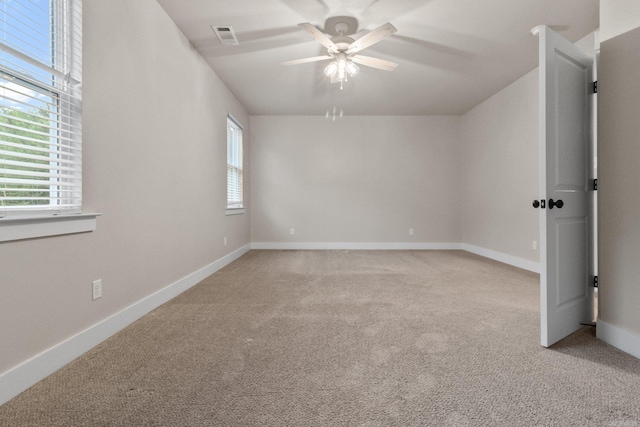 carpeted spare room featuring ceiling fan