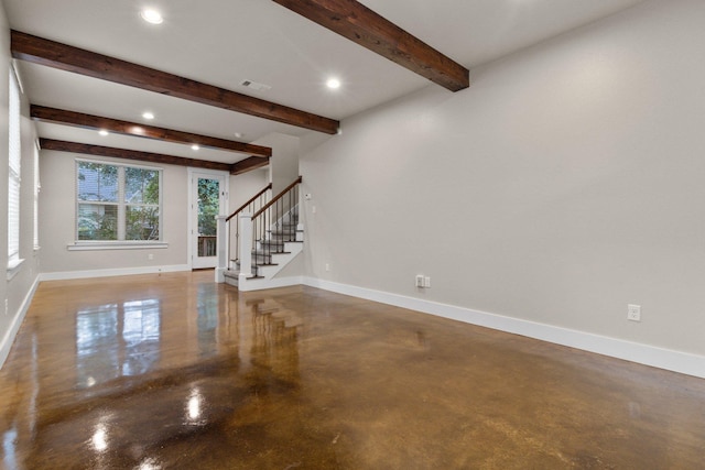 unfurnished living room featuring concrete floors and beam ceiling