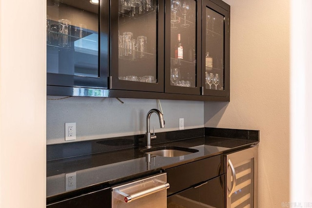 bar featuring wine cooler, sink, and dark stone countertops