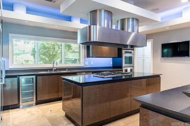 kitchen featuring sink, stainless steel appliances, a center island, wine cooler, and island exhaust hood