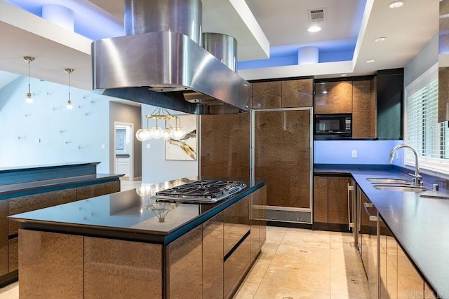 kitchen with island range hood, decorative light fixtures, black microwave, sink, and a center island