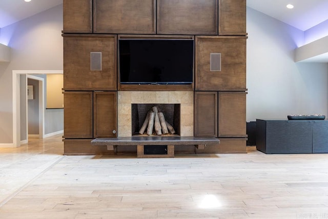 interior details featuring a tiled fireplace and hardwood / wood-style flooring