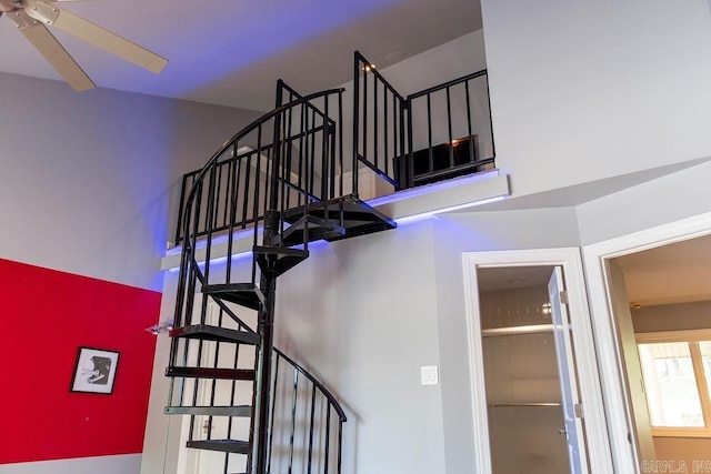 stairs featuring ceiling fan