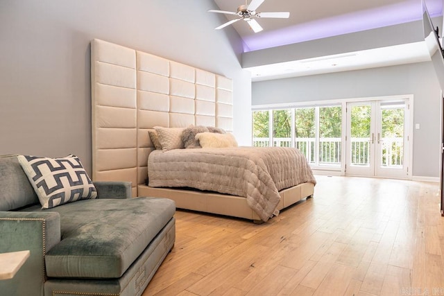 bedroom with ceiling fan, access to exterior, high vaulted ceiling, and light wood-type flooring