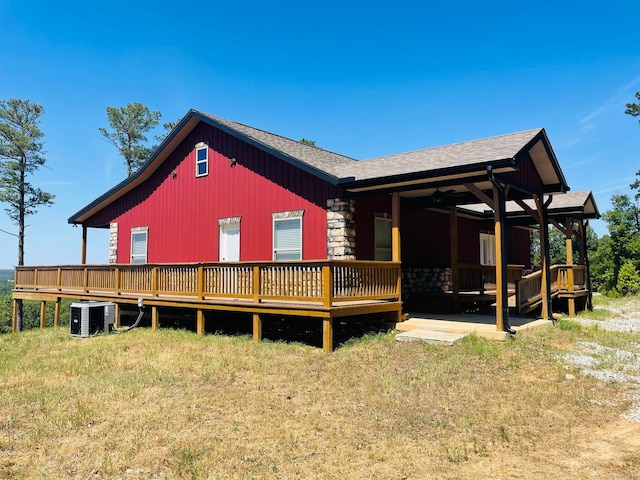 back of property featuring a wooden deck, central AC, and a lawn