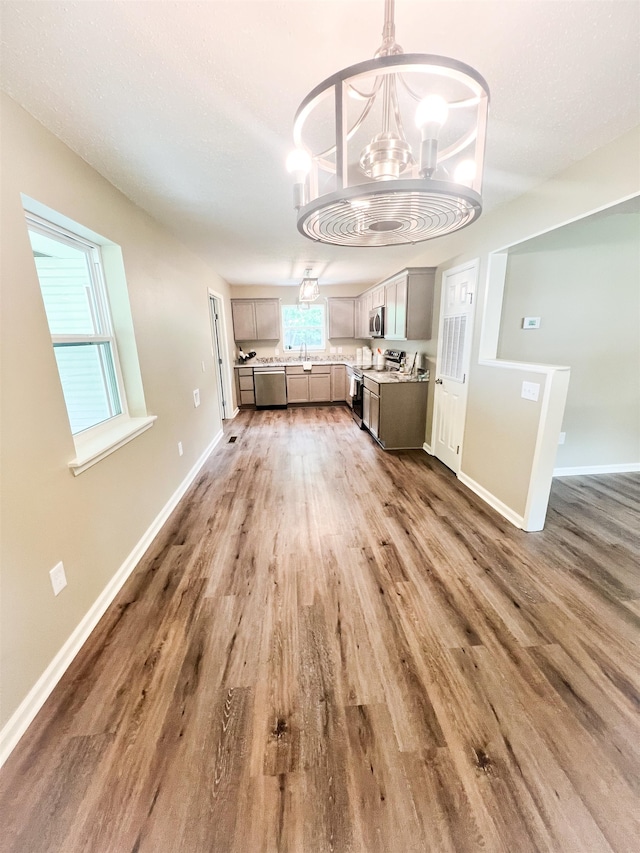 unfurnished dining area featuring an inviting chandelier, dark hardwood / wood-style floors, and sink