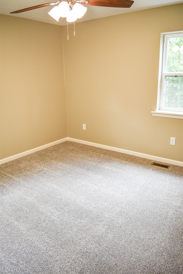 carpeted spare room featuring ceiling fan