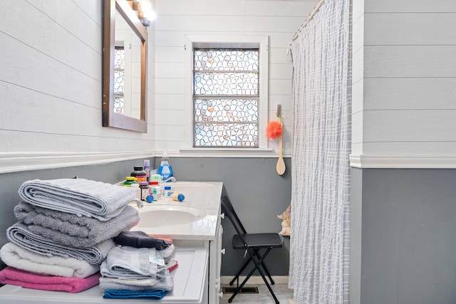 bathroom featuring vanity and wooden walls