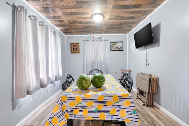 dining room with crown molding, wood ceiling, and light hardwood / wood-style floors