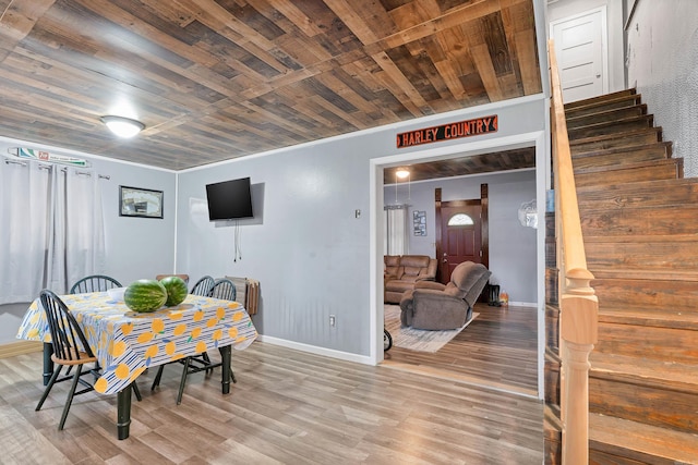 dining area with crown molding, wood-type flooring, and wooden ceiling