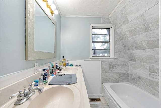 bathroom featuring crown molding, tile patterned flooring, vanity, a textured ceiling, and a tub to relax in