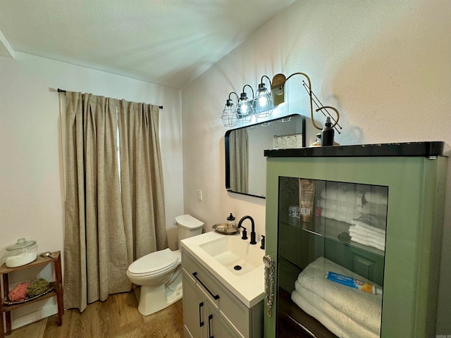 bathroom featuring vanity, wood-type flooring, and toilet