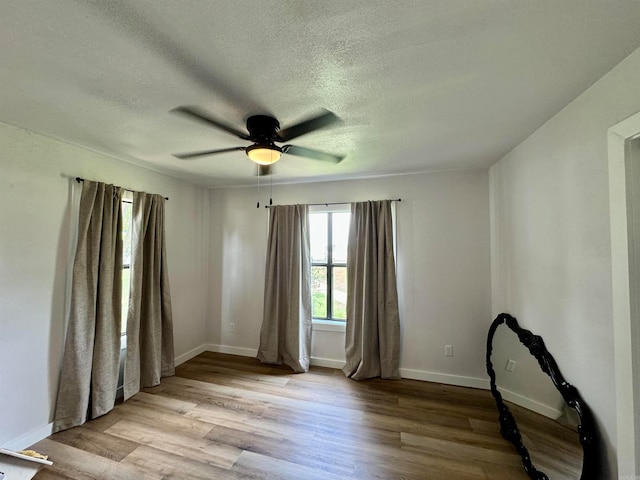 interior space featuring a textured ceiling, light wood-type flooring, and ceiling fan