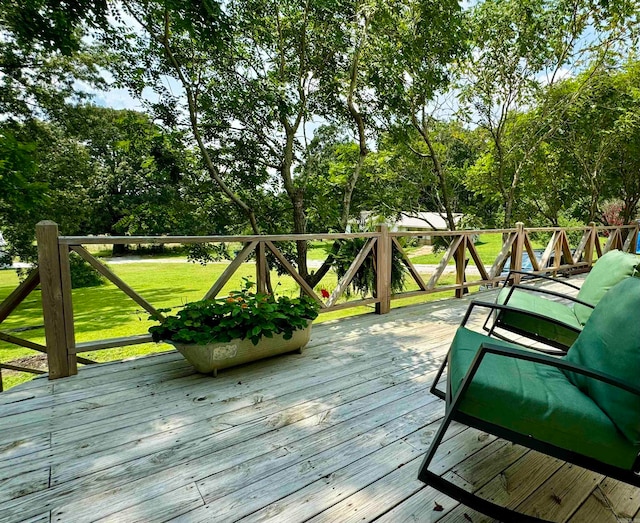 wooden deck featuring a lawn