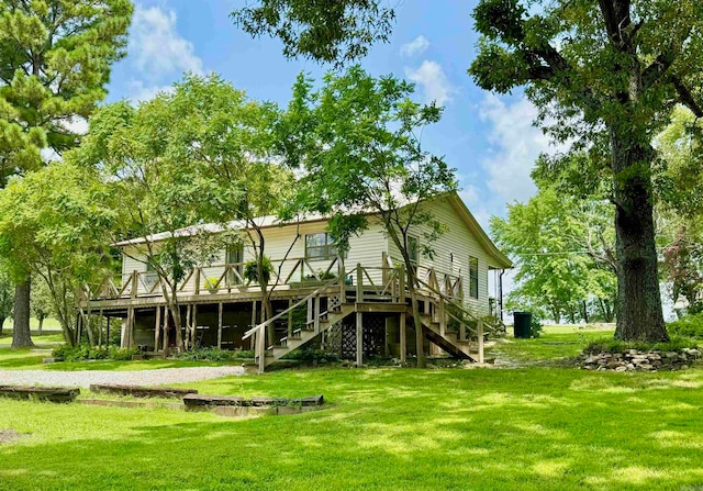 rear view of house featuring a wooden deck and a lawn