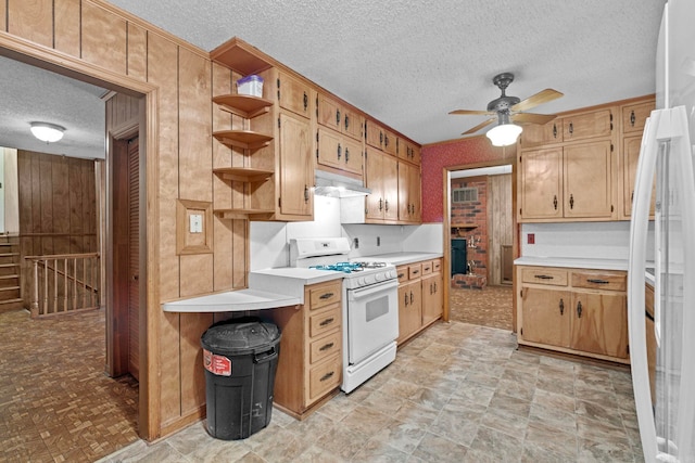 kitchen with a textured ceiling, ceiling fan, white range with gas stovetop, and light tile patterned floors