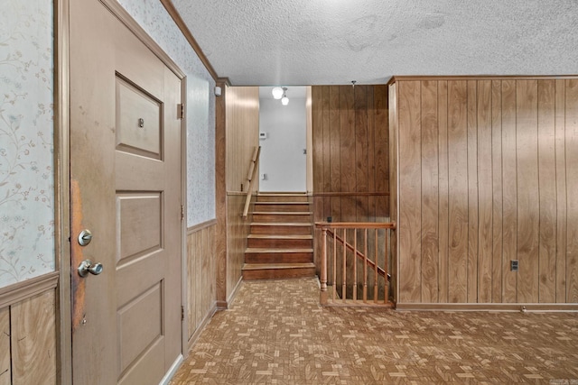 foyer entrance with parquet floors, a textured ceiling, and wooden walls