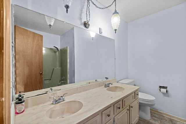 bathroom with a textured ceiling, tile patterned floors, toilet, and dual bowl vanity