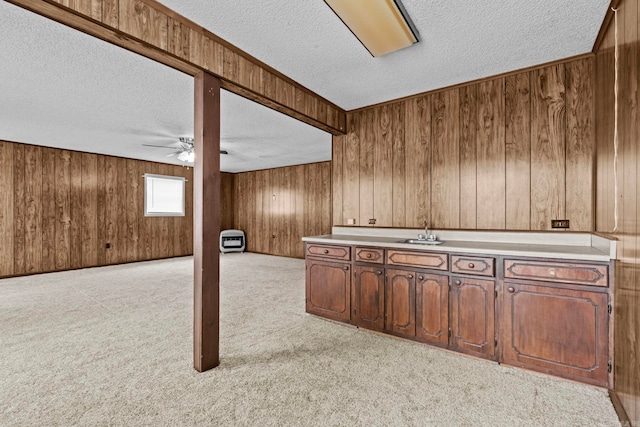 interior space with a textured ceiling, wooden walls, and light colored carpet