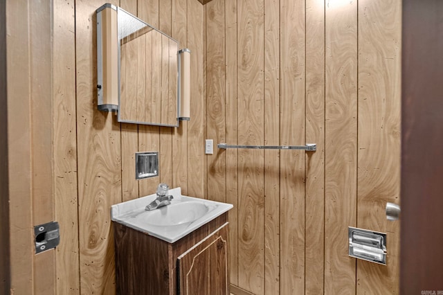 bathroom with vanity and wooden walls