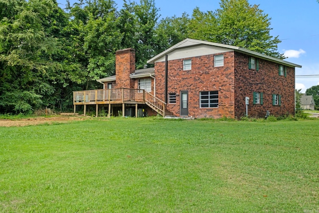 rear view of property featuring a wooden deck and a lawn