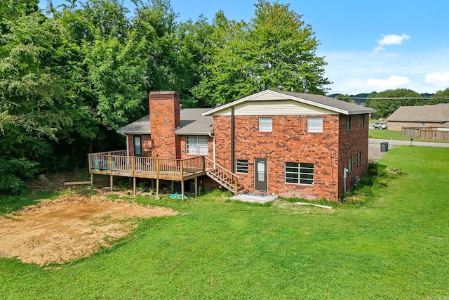 rear view of house with a deck and a yard