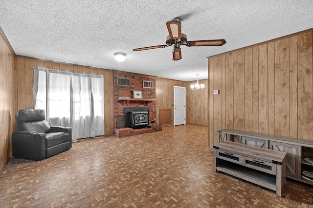 living room featuring parquet floors, a textured ceiling, and wooden walls