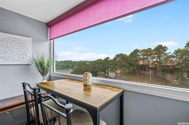 sunroom / solarium featuring a water view