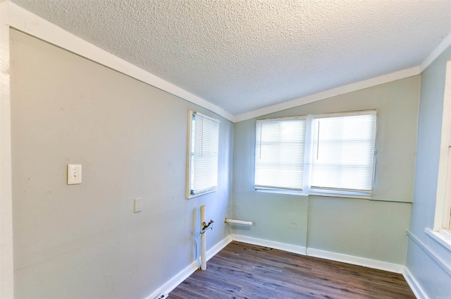 unfurnished room featuring vaulted ceiling, dark hardwood / wood-style floors, and a textured ceiling