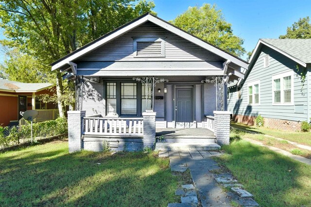 bungalow-style home featuring a porch and a front lawn