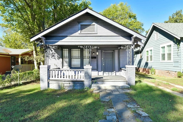 bungalow-style home with a front lawn and covered porch