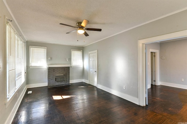 unfurnished living room with crown molding, ceiling fan, a textured ceiling, dark hardwood / wood-style flooring, and a brick fireplace