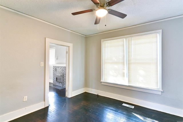 unfurnished room featuring ceiling fan, a stone fireplace, dark wood-type flooring, and a textured ceiling