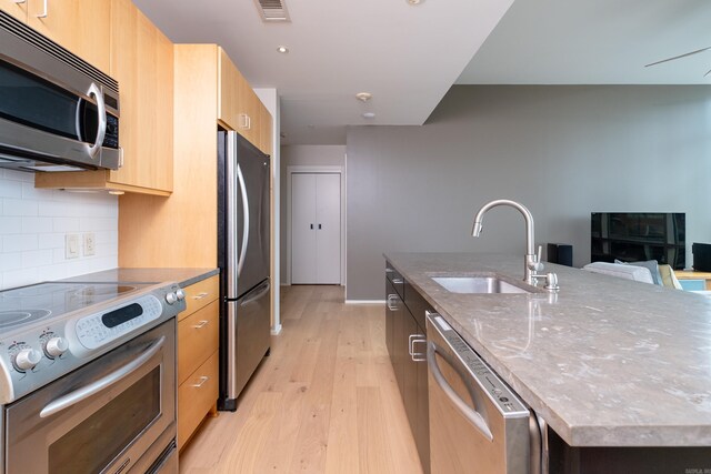 300 Third Unit 708, Little Rock, AR 72201 - kitchen with appliances with stainless steel finishes, a sink, modern cabinets, a large island with sink, and light brown cabinets