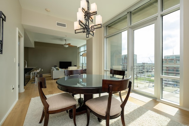 300 Third Unit 708, Little Rock, AR 72201 - dining room with ceiling fan, light wood-style floors, a chandelier, and baseboards